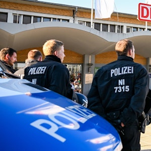 Polizisten stehen vor dem Hauptbahnhof in Wolfsburg und beobachten Fans von Werder Bremen