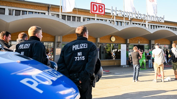 Polizisten stehen vor dem Hauptbahnhof in Wolfsburg und beobachten Fans von Werder Bremen