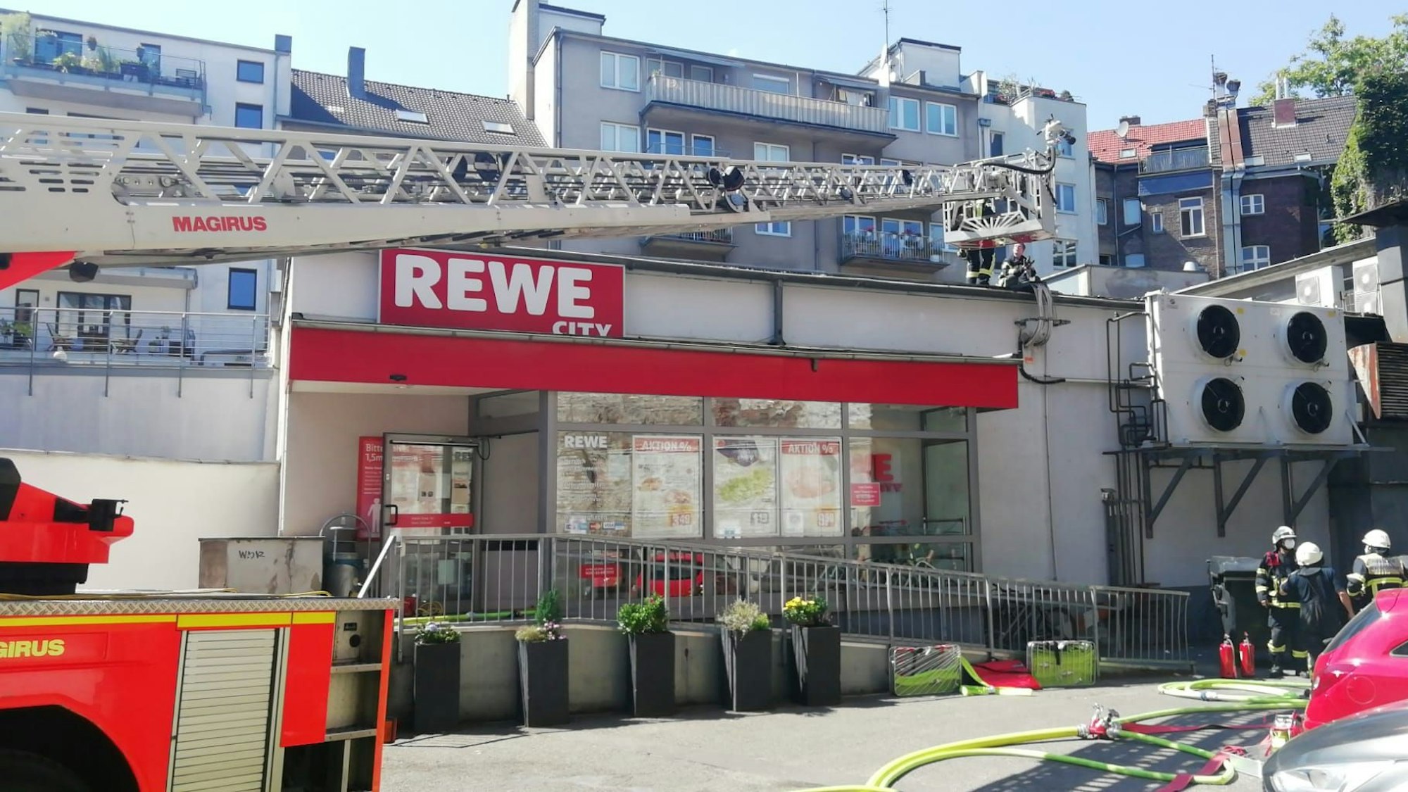 Einsatzkräfte der Feuerwehr löschen den Brand in einem Rewe-Markt in der Kölner Südstadt.