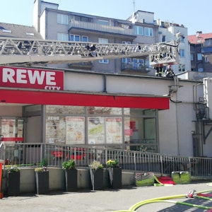 Einsatzkräfte der Feuerwehr löschen den Brand in einem Rewe-Markt in der Kölner Südstadt.