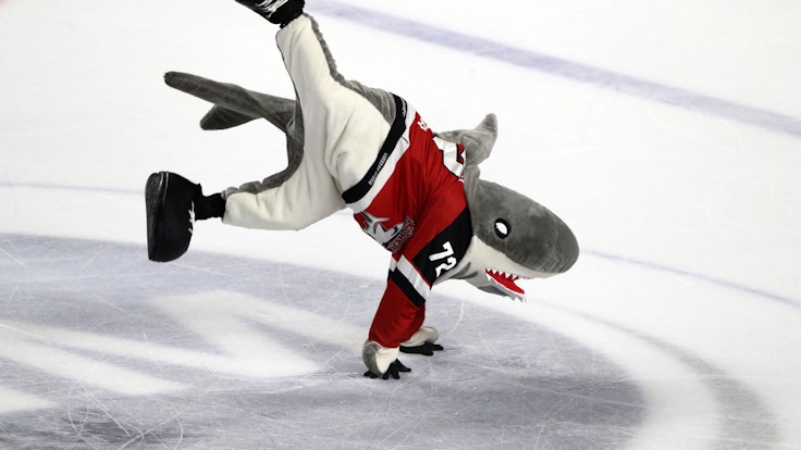 KEC-Maskottchen Sharky tanzt auf der Eisfläche.