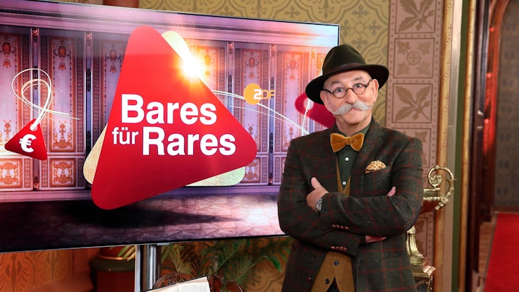 Moderator Horst Lichter steht neben dem Logo der Sendung «Bares für Rares» (undatierte Aufnahme). Die Trödelshow hat dem ZDF den klaren TV-Quotensieg am 27.11.2019 beschert. (zu dpa "Antiquitätenshow «Bares für Rares» bringt ZDF den Quotensieg") +++ dpa-Bildfunk +++