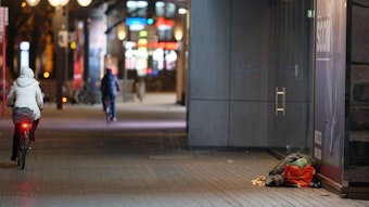 Ein Mensch liegt in der Innenstadt in einem Schlafsack im Eingang zu einem Geschäft. Auf dem Konrad-Adenauer-Platz am Düsseldorfer Hauptbahnhof urinierte der 18-Jährige auf Obdachlose und filmte auch noch die Tat.