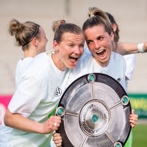 Wolfsburgs Alexandra Popp (l) und Wolfsburgs Sandra Starke halten nach dem Spiel eine Nachbildung der Meisterschale in der Hand und feiern die Deutsche Meisterschaft.