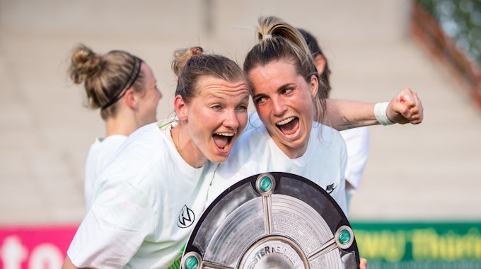 Wolfsburgs Alexandra Popp (l) und Wolfsburgs Sandra Starke halten nach dem Spiel eine Nachbildung der Meisterschale in der Hand und feiern die Deutsche Meisterschaft.