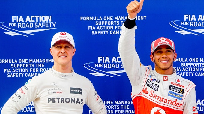 Michael Schumacher (l), damaliger Fahrer für das Team Mercedes AMG, und der Brite Lewis Hamilton, damaliger Fahrer für McLaren Mercedes, stehen nach einem Qualifying in der Formel-1 nebeneinander.