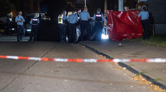 Solingen: Polizeibeamte halten an einem Tatort einen Sichtschutz bei der Arbeit der Spurensicherung. Ein Mann ist mit einem Messer getötet worden.