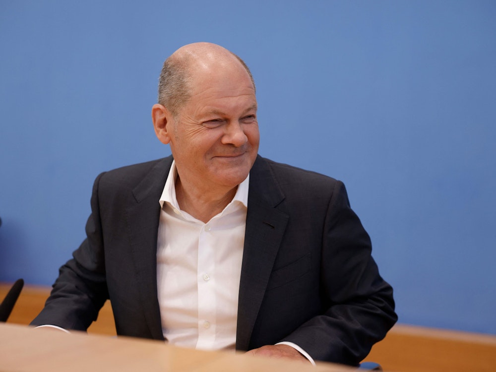 Olaf Scholz schmunzelt gut gelaunt auf einer Pressekonferenz am 11. August 2022.