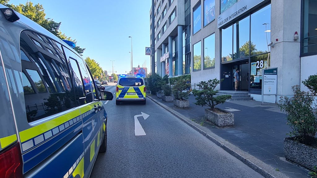 Einsatzfahrzeuge der Polizei stehen vor dem Haus der Integration. Im Wuppertaler Haus der Integration ist eine Mitarbeiterin der Behörde vermutlich mit einem Messer schwer verletzt worden.
