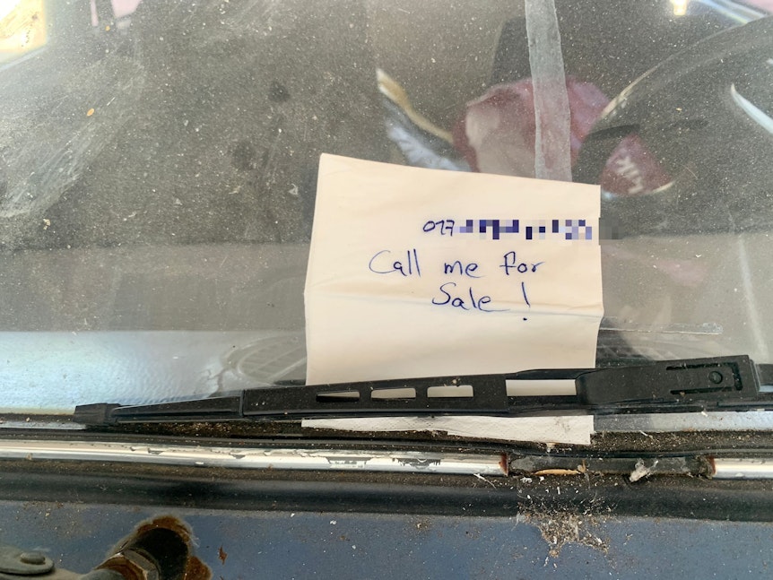 Ein Zettel mit der Aufschrift „Call me for sale“ ist an einem zerstörten ukrainischen Auto am Kölner Hauptbahnhof angebracht.