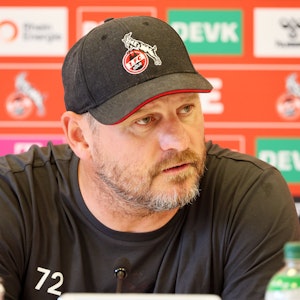 Steffen Baumgart mit FC-Cap auf der Pressekonferenz.