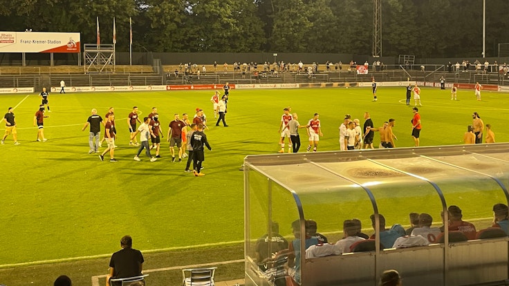 Fan-Chaoten von RW Oberhausen und dem 1. FC Köln auf dem Spielfeld.