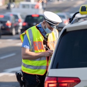 Ein Polizist kontrolliert in Darmstadt einen Taxifahrer.