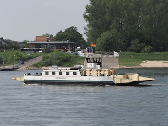 Die Hitdorfer Fähre auf dem Rhein vor dem Ufer in Köln-Langel.