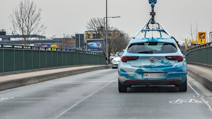 Ein Fahrzeug von Google Street View mit einer aufgebauten Kamera fährt über eine Brücke in Köln-Lövenich.