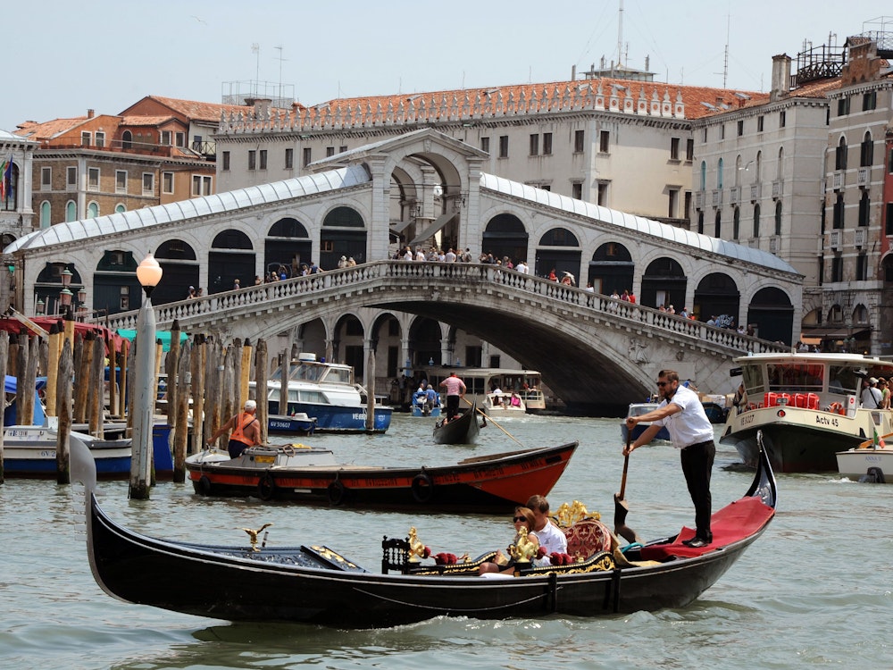 Gondeln, Boote sowie ein Vaporetto fahren auf dem Canale Grande vor der Rialtobrücke in Venedig (Italien). Das Foto wurde im Mai 2011 aufgenommen.