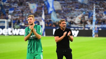 Gladbach-Profi Christoph Kramer (l.) und Trainer Daniel Farke (r.) nach dem Unentschieden von Fußball-Bundesligist Borussia Mönchengladbach beim FC Schalke 04 am 13. August 2022. Die beiden klatschen in die Hände.