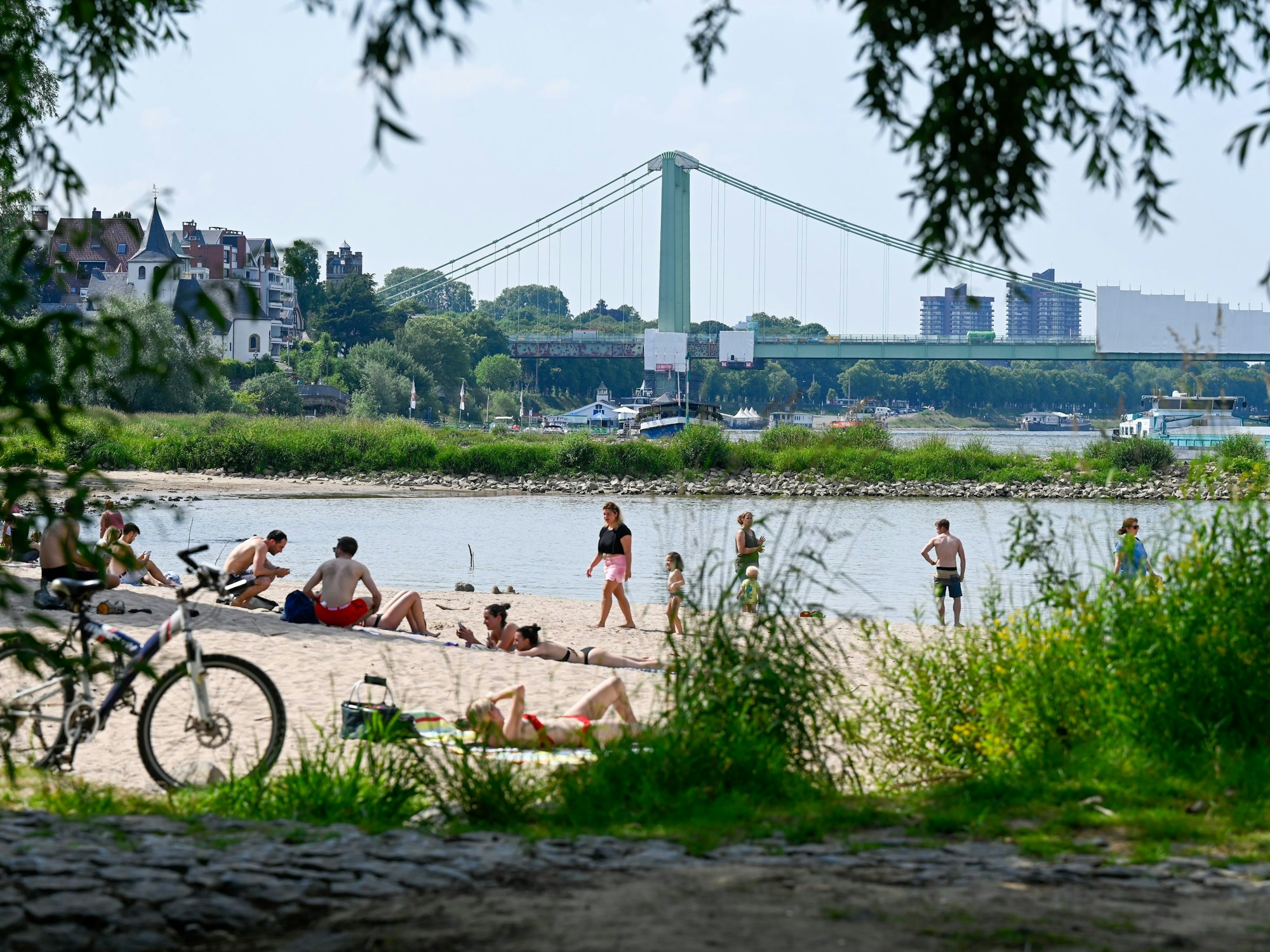 Bei schönem Wetter sonnen sich die Menschen an den Stränden des Rheins und suchen Abkühlung im Fluss.