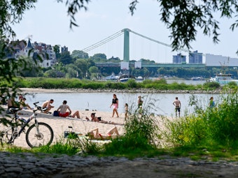 Bei schönem Wetter sonnen sich die Menschen an den Stränden des Rheins und suchen Abkühlung im Fluss.