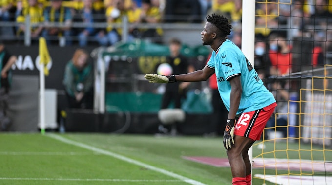 Leverkusens Edmond Tapsoba steht beim Spiel in Dortmund mit Torwarttrikot im Tor und stellt eine Freistoßmauer.