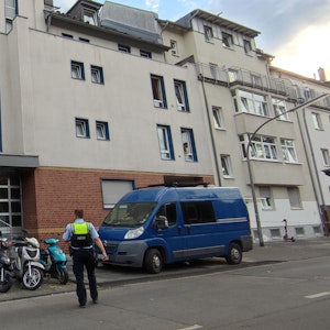 Kräfte der Polizei stehen vor einem Haus in der Gießener Straße in Köln.