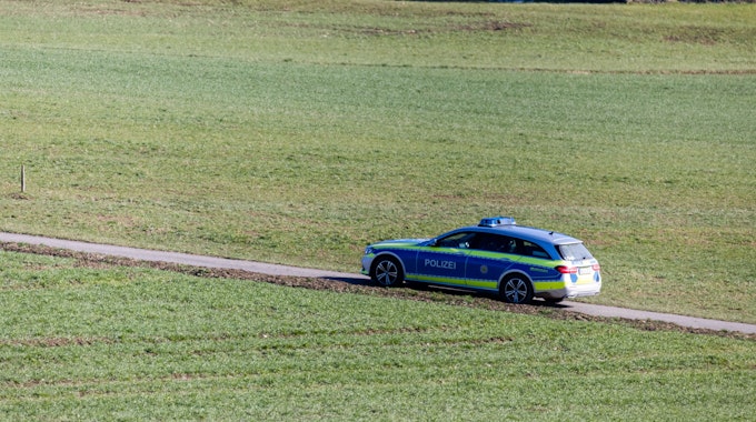Ein Polizeifahrzeug fährt über einen Feldweg in Baden-Württemberg.