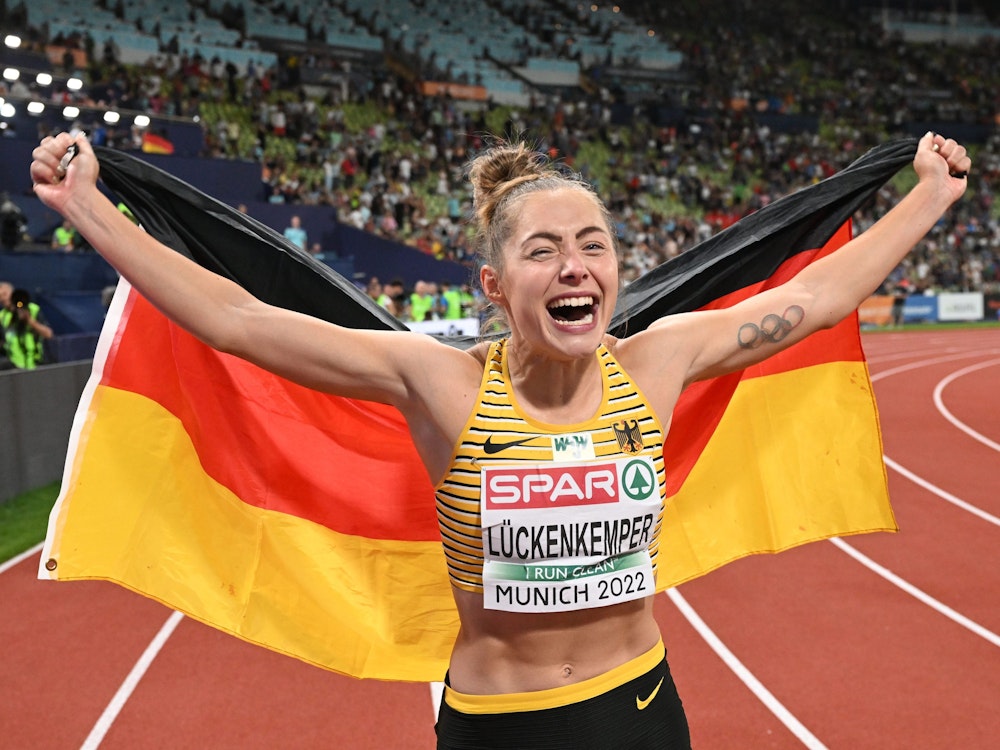 Die Leichtathletin Gina Lückenkemper jubelt mit der deutschen Fahne.