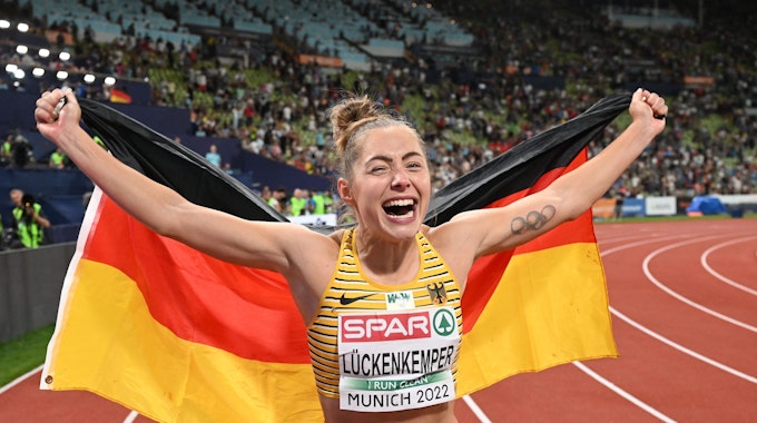 Die Leichtathletin Gina Lückenkemper jubelt mit der deutschen Fahne.