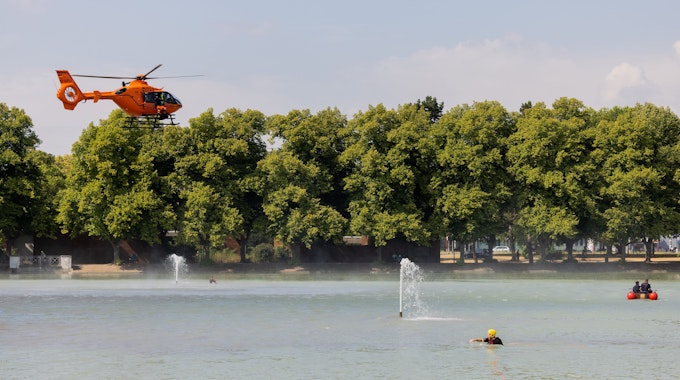 Einsatzkräfte suchen mit Helikopter und Booten nach einer Person, die Zeugen in dem Gewässer am Aachener Weiher gesehen haben wollen.