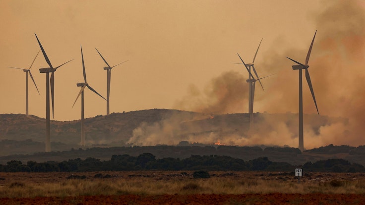 Rauch steigt bei Windrädern wegen eines Brandes nahe der Autobahn A23. Bei den verheerenden Waldbränden in der spanischen Urlaubsregion Valencia sind mehrere Passagiere eines Regionalzuges im Gebiet Bejís verletzt worden.