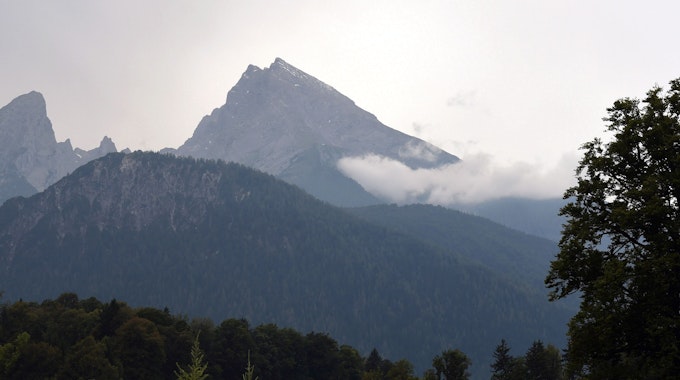 Wolken und Sonne umgeben den Gipfel des Watzmann-Massivs. Er ist der zentrale Gebirgsstock der Berchtesgadener Alpen.