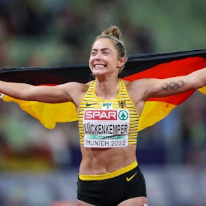 Gina Lückenkemper rennt nach ihrem Triumph mit einer Deutschland-Flagge durch das Olympiastadion in München.
