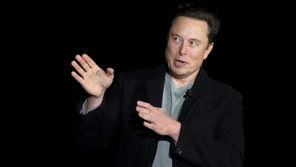 Elon Musk spricht und gestikuliert mit seinen Händen.