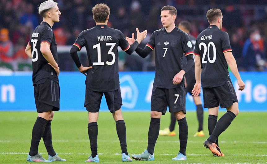 Er soll Thema in Gladbach sein: DFB-Nationalspieler Julian Draxler (2.v.r.) klatscht Thomas Müller (2.v.l.) beim Länderspiel gegen die Niederlande am 29. März 2022 in Amsterdam ab. Die deutschen Spieler tragen schwarze Trikots.