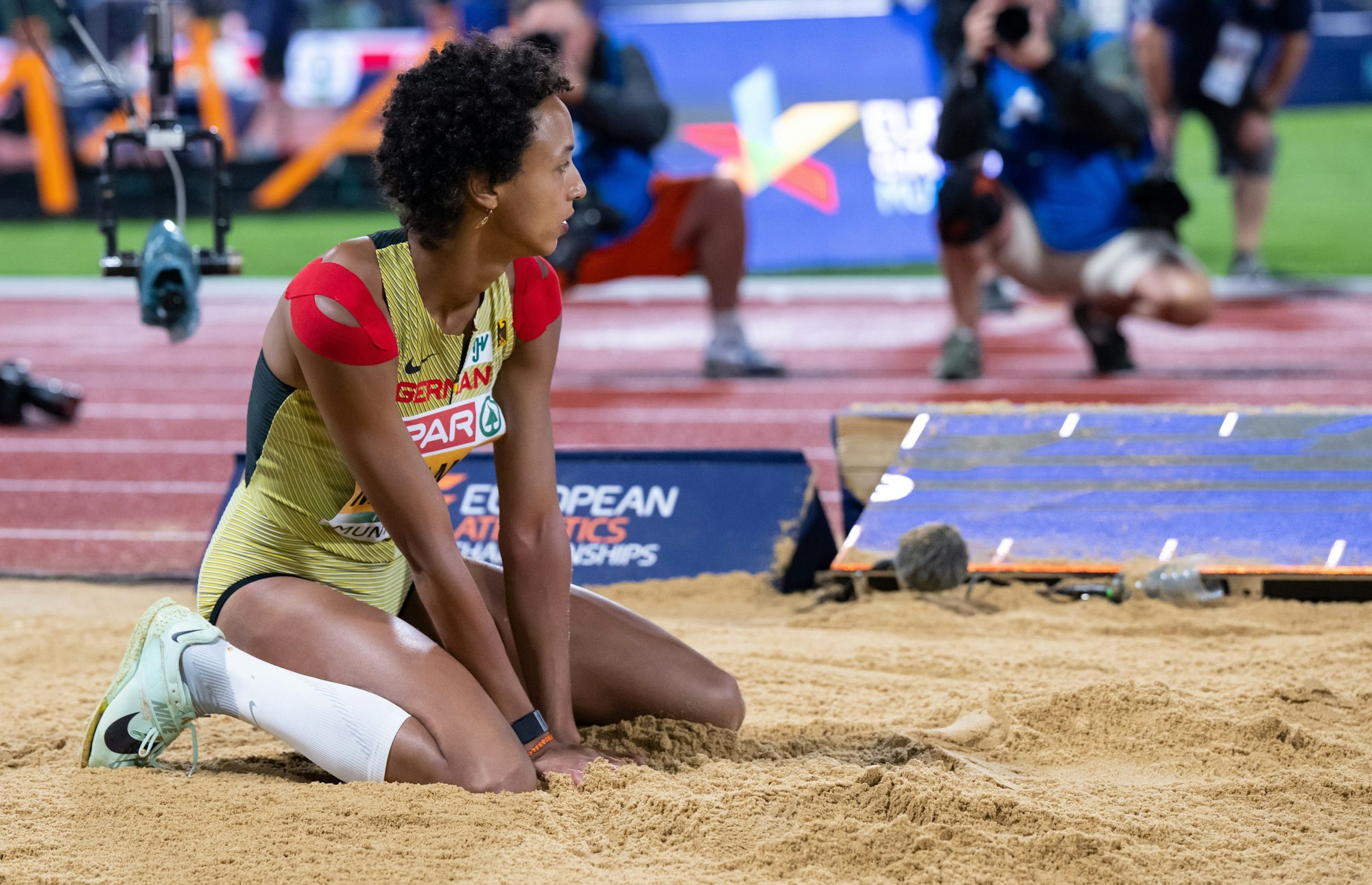 Malaika Mihambo sitzt bei der Leichtathletik-EM nach einem Sprung in der Sandgrube.