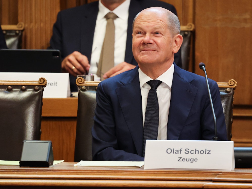 Bundeskanzler Olaf Scholz (SPD) sitzt auf seinem Platz auf der Senatsbank in Hamburg.