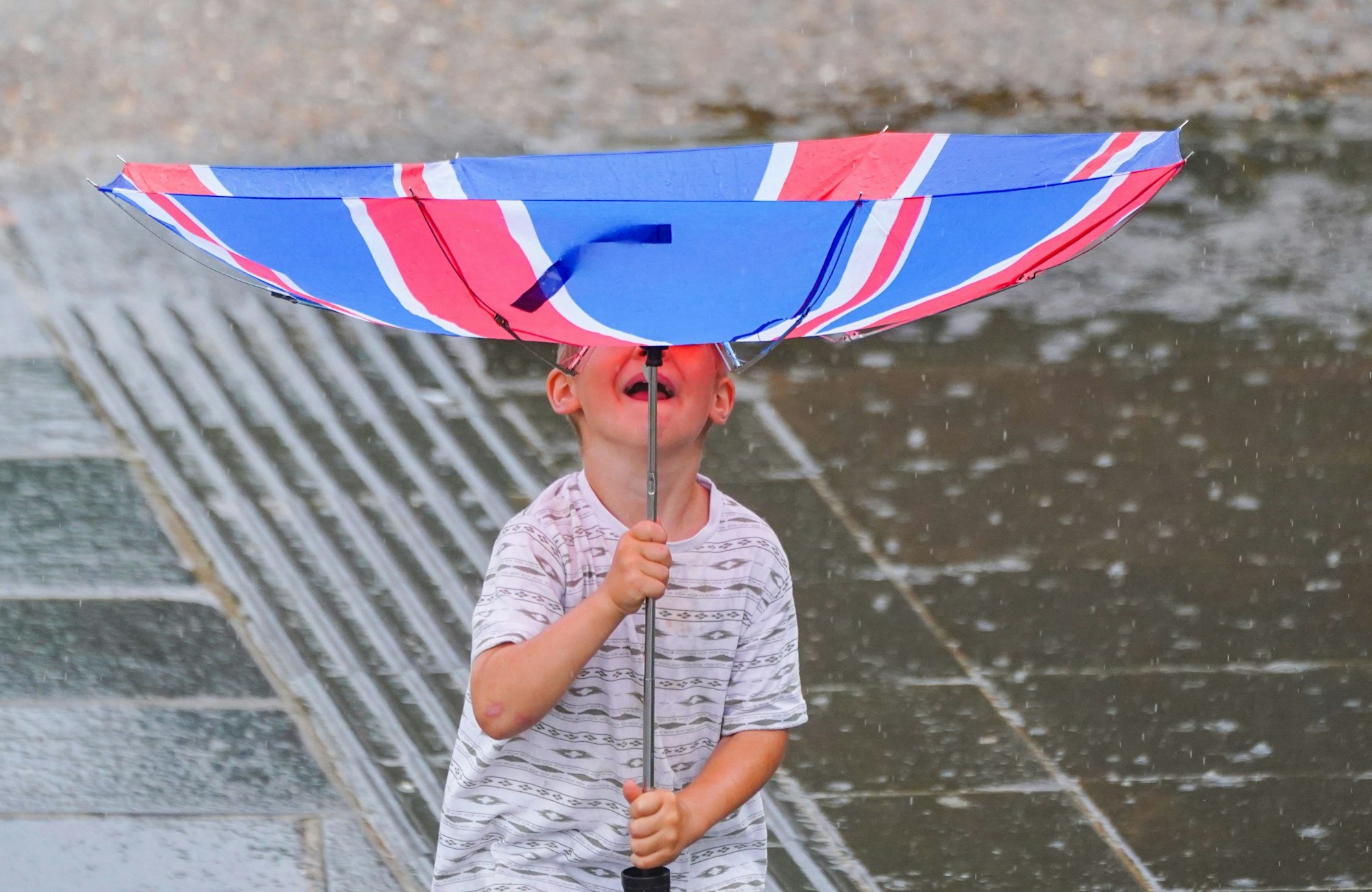 Ein kleiner Junge kämpft bei Wind und Regen in London mit seinem Regenschirm. Der britische Wetterdienst Met Office hatte eine Unwetterwarnung  ausgegeben.