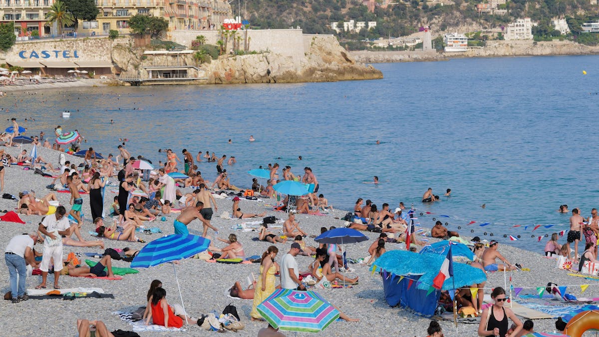 Menschen verbringen die Zeit an einem Strand von Nizza an der Côte d'Azur. Die Aufnahme stammt von Juli 2022.