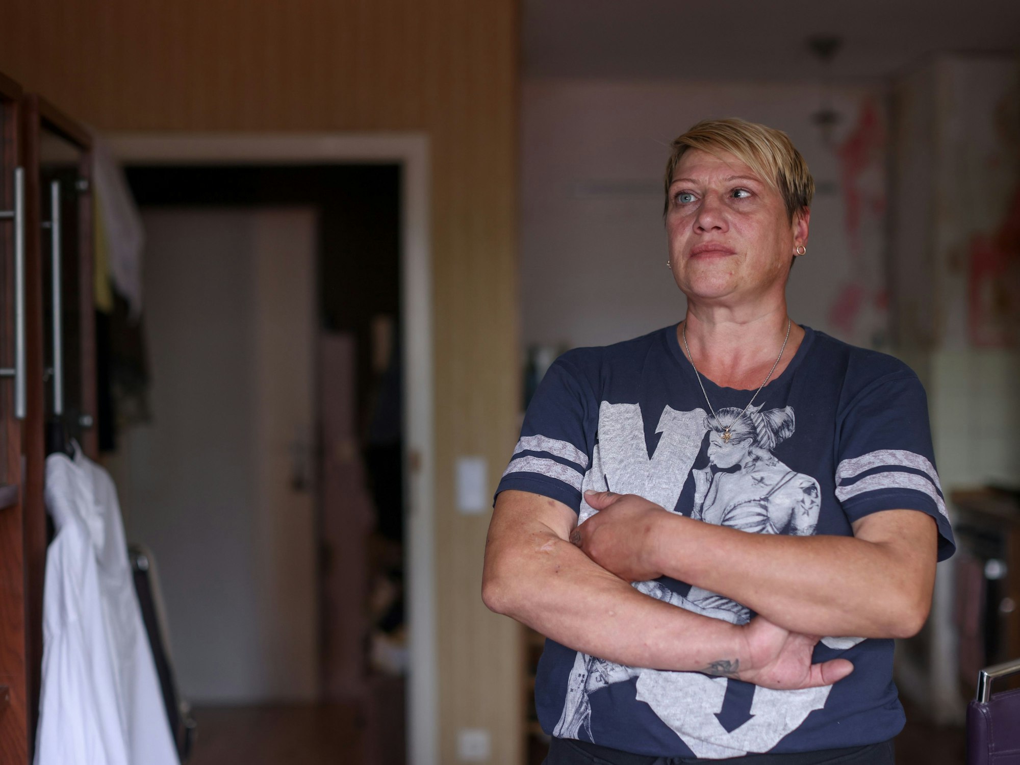 Die Kölnerin Angela Aranov steht mit verschränkten Armen in ihrer Wohnung.