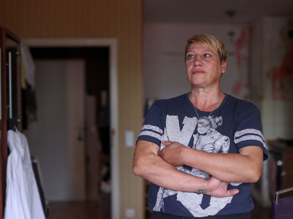 Angela Aranov steht mit verschränkten Armen in ihrer Wohnung.