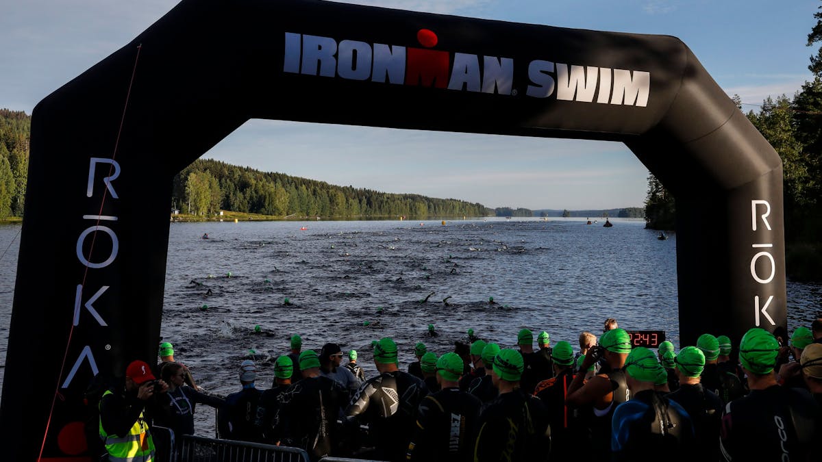 Triathletinnen und Triathleten gehen beim Ironman in Finnland ins Wasser.