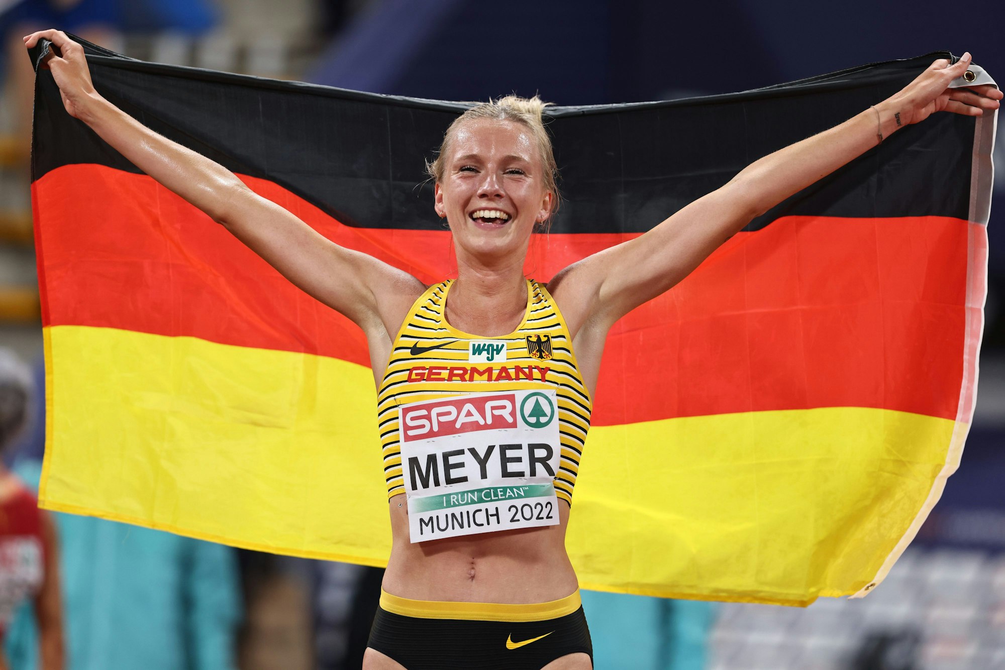Lea Meyer feiert bei der EM ihre Medaille mit der deutschen Fahne um die Schultern.