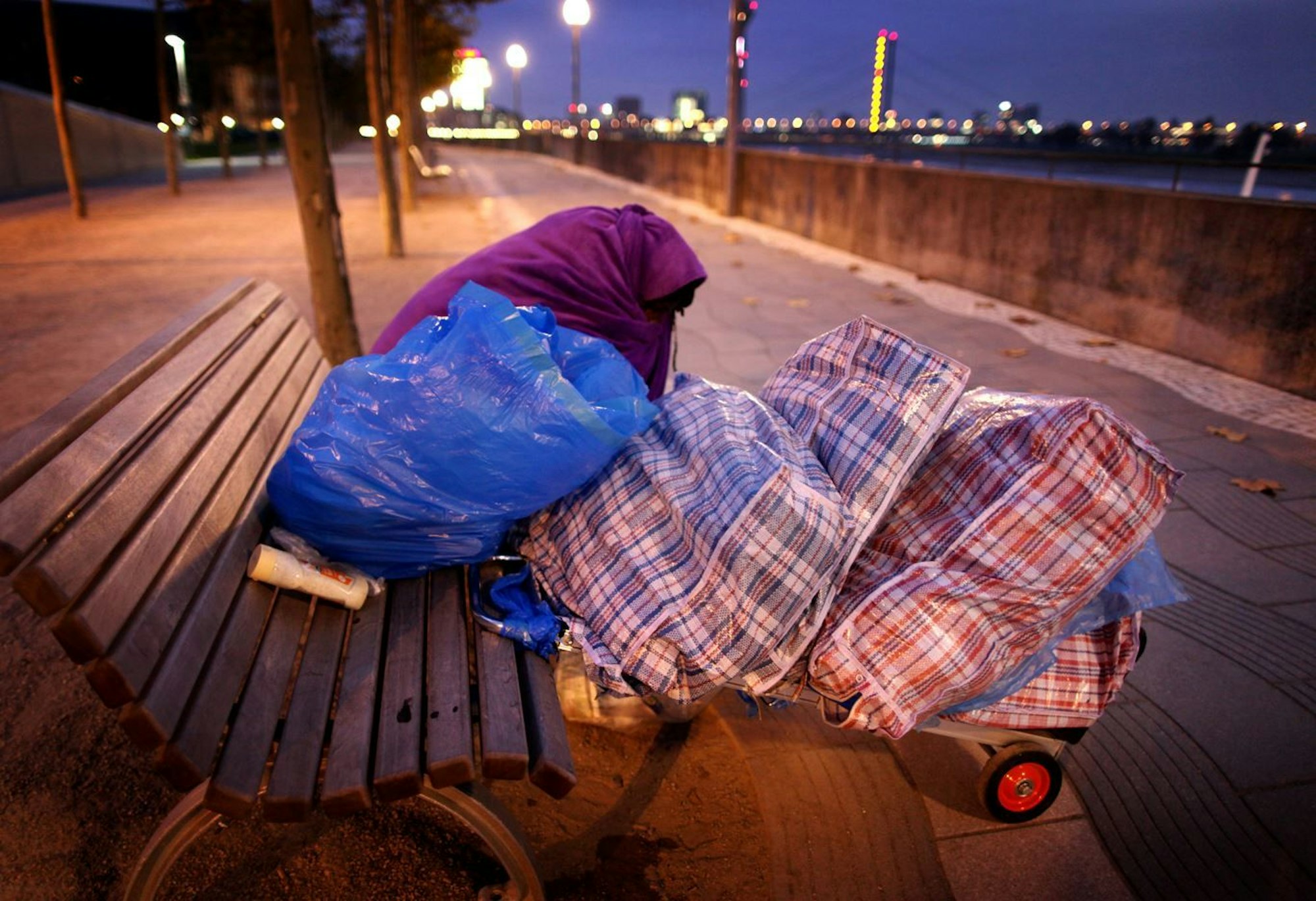 Ein Obdachloser sitzt am 18. November 2011 in Düsseldorf auf einer Bank am Rhein. Am Wochenende ist Andy, einer der Verkäufer der Obdachlosen-Zeitung „fiftyfifty“ gestorben.