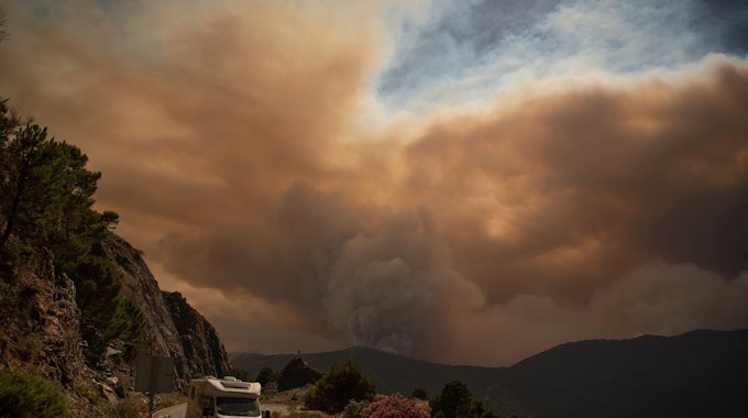 Ein Wohnmobil fährt aus dem Waldbrand-Gebiet der Sierra Bermeja heraus.