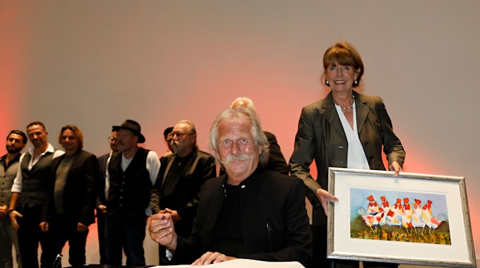 Henning Krautmacher trägt sich neben Henriette Reker in das Buch der Stadt Köln ein.