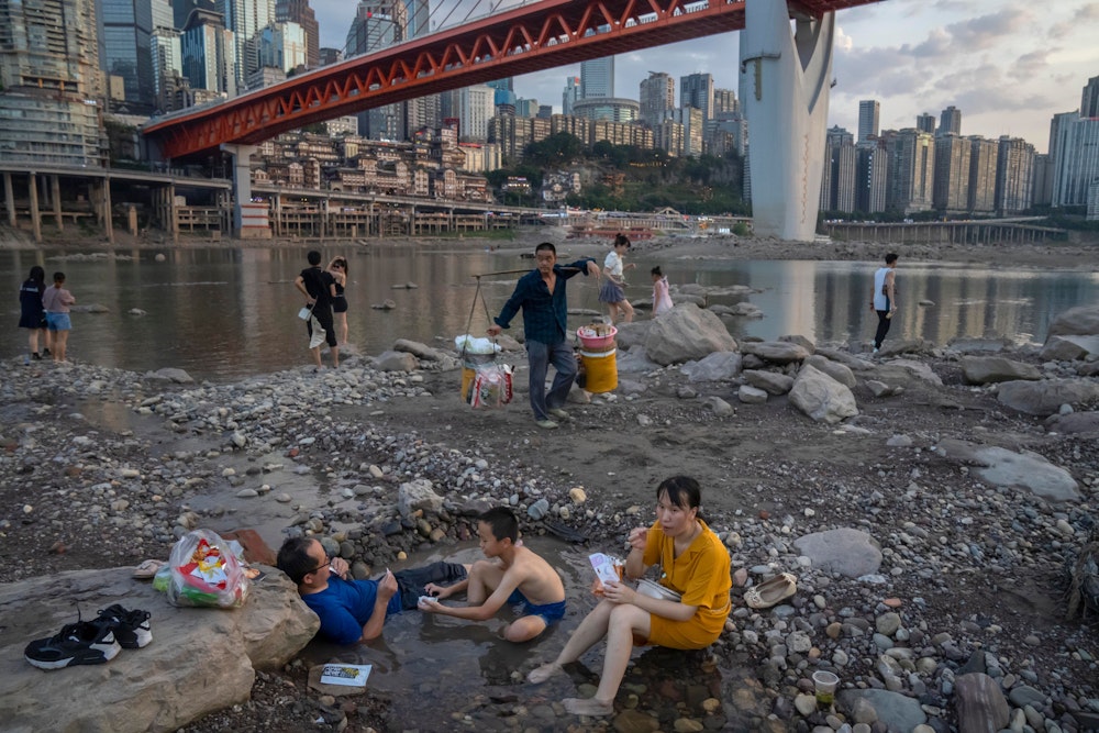 Chongqing: Menschen sitzen in einem flachen Wasserbecken im Flussbett des Jialing-Flusses, eines Nebenflusses des Jangtse, in der südwestchinesischen Stadt Chongqing.