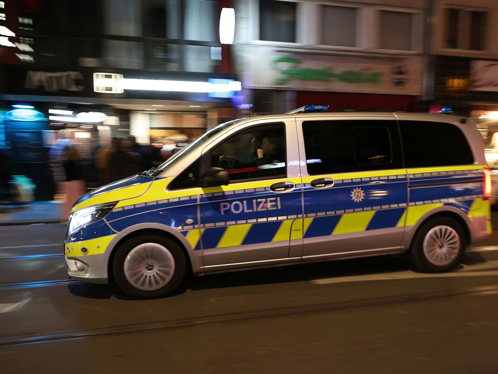 Ein Einsatzwagen der Polizei fährt über die Zülpicher Straße.