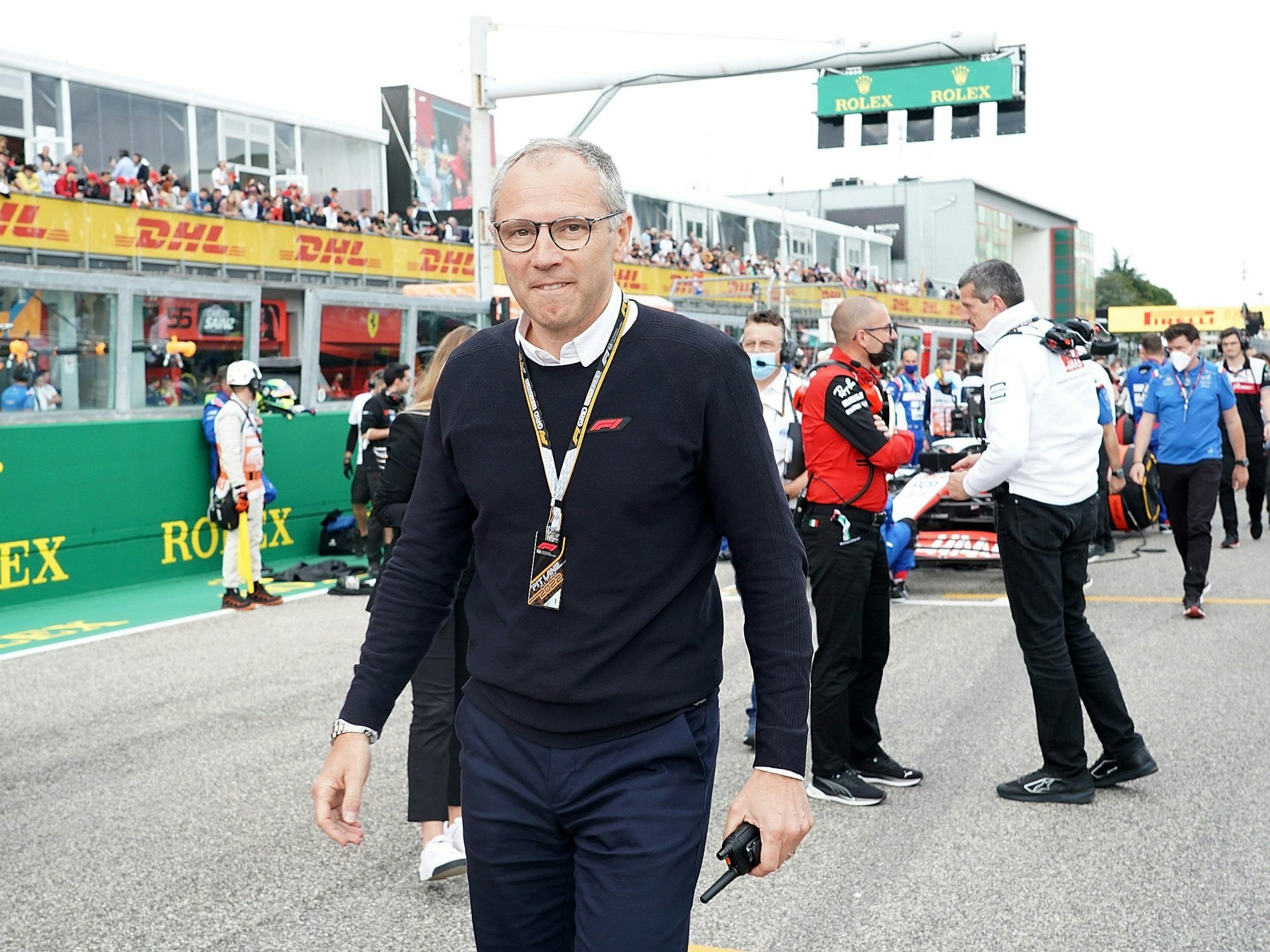 Formel 1 Chef Stefano Domenicali leicht grinsend in der Startaufstellung.