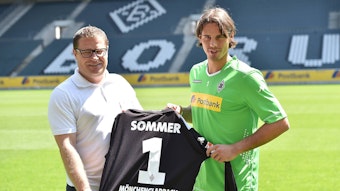 Gladbach-Keeper Yann Sommer (r.) und Ex-Borussia-Manager Max Eberl (l.), hier zu sehen am 23. Juli 2014 im Borussia-Park. Die beiden halten ein Trikot mit der Rückennummer eins in den Händen.