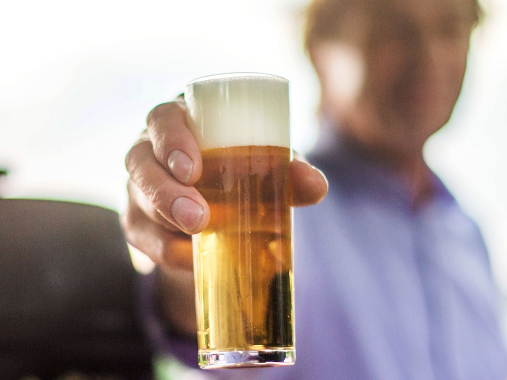 Ein frisch gezapftes Kölsch wird auf einer Party in die Kamera gehalten. Bier wird voraussichtlich schon bald deutlich teurer.